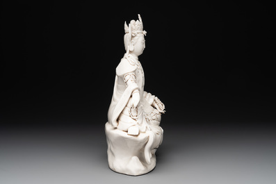 A Chinese Dehua blanc de Chine seated Guanyin holding a sutra, 20th C.