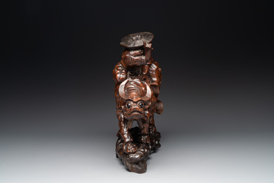 A Chinese carved wooden group of a boy riding a water buffalo, 20th C.