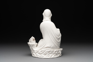 A Chinese Dehua blanc de Chine figure of a seated Guanyin on wooden stand, 19/20th C.