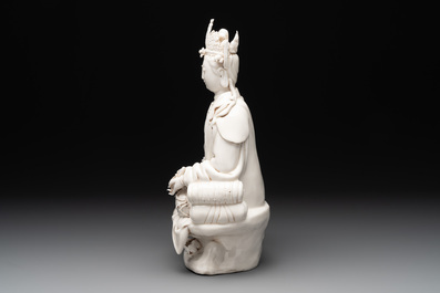 A Chinese Dehua blanc de Chine seated Guanyin holding a sutra, 20th C.