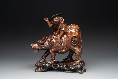 A Chinese carved wooden group of a boy riding a water buffalo, 20th C.