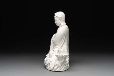 A Chinese Dehua blanc de Chine figure of a seated Guanyin on wooden stand, 19/20th C.