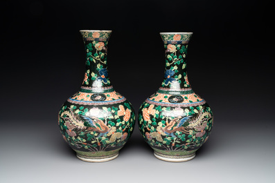 A pair of Chinese famille verte black-ground 'phoenix' bottle vases, Qianlong mark, 19th C.