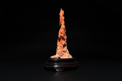 A Chinese red coral group of boys and bitter gourds on wooden stand, 19/20th C.