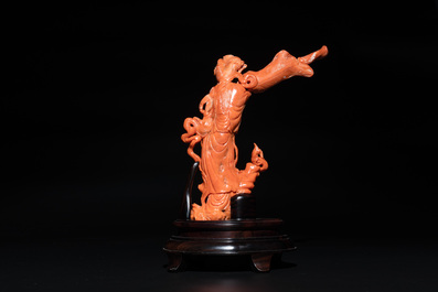 A Chinese red coral female deity holding a fan, 19/20th C.