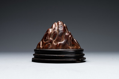 A Chinese agarwood carving of a mountain on wooden stand, 18/19th C.