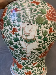A Chinese wucai 'boy and peony scroll' vase and cover, 17th C.