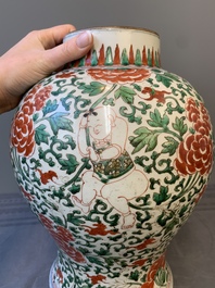 A Chinese wucai 'boy and peony scroll' vase and cover, 17th C.
