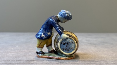 A polychrome Dutch Delft model of a boy rolling a 'wijn azijn' barrel, 18th C.