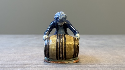 A polychrome Dutch Delft model of a boy rolling a 'wijn azijn' barrel, 18th C.