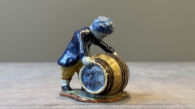 A polychrome Dutch Delft model of a boy rolling a 'wijn azijn' barrel, 18th C.