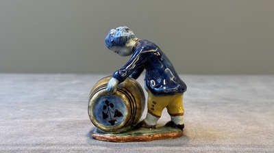 A polychrome Dutch Delft model of a boy rolling a 'wijn azijn' barrel, 18th C.