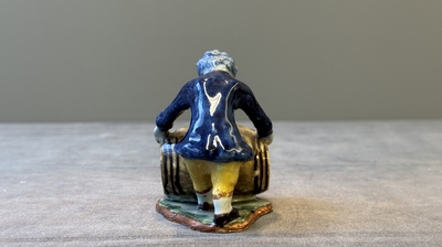 A polychrome Dutch Delft model of a boy rolling a 'wijn azijn' barrel, 18th C.