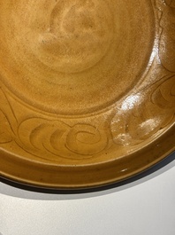A Chinese incised brown-glazed Longquan dish with floral design, Ming
