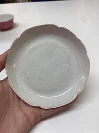 Three Chinese ruby-ground famille rose plates and a cup, 19th C.