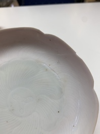 Three Chinese ruby-ground famille rose plates and a cup, 19th C.