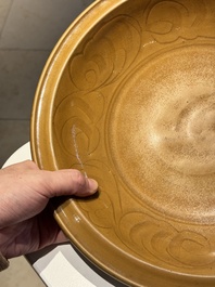 A Chinese incised brown-glazed Longquan dish with floral design, Ming