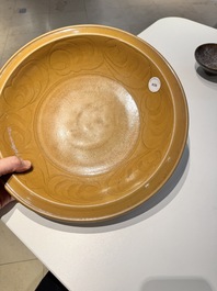 A Chinese incised brown-glazed Longquan dish with floral design, Ming