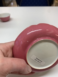 Three Chinese ruby-ground famille rose plates and a cup, 19th C.