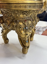 A large Chinese precious stone-inlaid gilt bronze 'elephant' tripod censer and cover on wooden stand, 19th C.