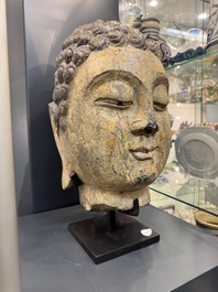 A large Chinese stone head of Buddha with traces of gilding and polychromy, Ming