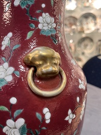 A pair of Chinese famille rose ruby-ground 'landscape' vases, 19th C.