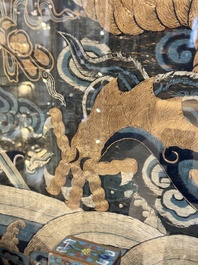 A Chinese embroidered silk tapestry with a five-clawed dragon among clouds and bajixiang, 18/19th C.