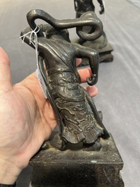 A pair of Chinese bronze guardians on stands, 17/18th C.