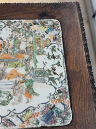 A pair of Chinese famille verte 'narrative' plaques mounted in hardwood tables, 19th C.