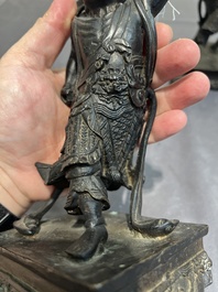 A pair of Chinese bronze guardians on stands, 17/18th C.