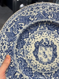 A large Chinese blue and white armorial dish with the arms of the Coelho family, Kangxi