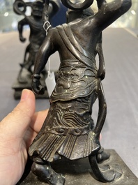 A pair of Chinese bronze guardians on stands, 17/18th C.