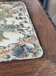 A pair of Chinese famille verte 'narrative' plaques mounted in hardwood tables, 19th C.