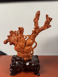 A Chinese red coral group of goddesses on wooden stand, 19/20th C.