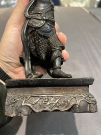 A pair of Chinese bronze guardians on stands, 17/18th C.