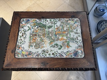 A pair of Chinese famille verte 'narrative' plaques mounted in hardwood tables, 19th C.