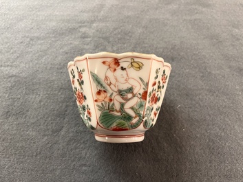 A fine Chinese famille verte 'boy and lotus' flower-shaped cup and a wooden stand, Kangxi