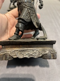 A pair of Chinese bronze guardians on stands, 17/18th C.