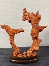 A Chinese pink-orange coral group of a goddess of spring, a wise man and children in a pine tree, 19/20th C.