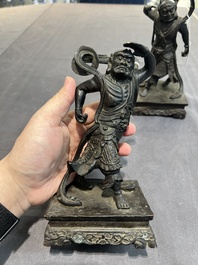 A pair of Chinese bronze guardians on stands, 17/18th C.