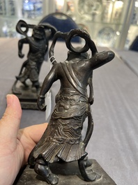 A pair of Chinese bronze guardians on stands, 17/18th C.