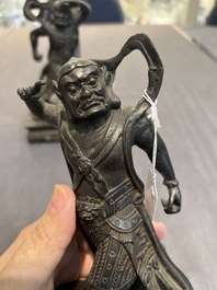 A pair of Chinese bronze guardians on stands, 17/18th C.