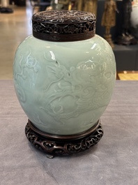 A Chinese celadon-glazed 'dragon' jar with reticulated wooden cover and stand, Qianlong