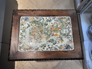 A pair of Chinese famille verte 'narrative' plaques mounted in hardwood tables, 19th C.