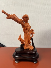 A Chinese red coral female deity holding a fan, 19/20th C.