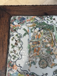 A pair of Chinese famille verte 'narrative' plaques mounted in hardwood tables, 19th C.