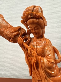 A Chinese red coral female deity holding a fan, 19/20th C.