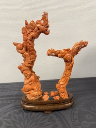 A Chinese pink-orange coral group of a goddess of spring, a wise man and children in a pine tree, 19/20th C.