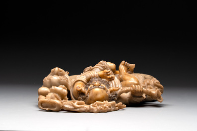 A Chinese carved group of a Luohan with two tigers, 20th C.