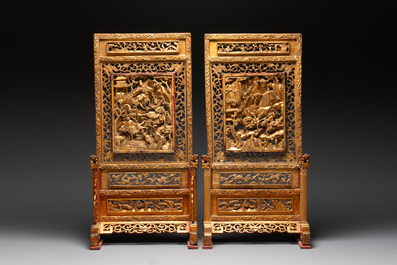 A pair of Chinese gilt-lacquered openworked wooden table screens with warriors on horseback, 19th C.